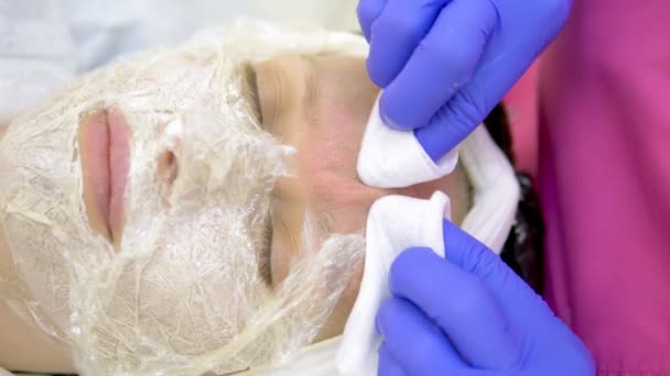 Närbild. ansikte av en kvinna vid en kosmetolog utnämning. Manuell ansiktsrengöring. Rengöring ansiktshud, kosmetolog pressade pormaskar. — Stockvideo