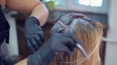 Close. saç boyama konsepti. kuaför renklendirici bir fırça ile bir kadının saç boyası