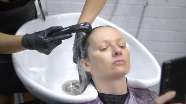 Prozess der Haarwäsche in einem Friseur. Mädchen in einem Schönheitssalon. Haare waschen, Haarpflege, Gesundheit. — Stockvideo