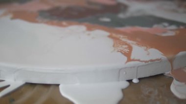 Sıvı akrilik atölyesi. Akışkan sanat. kadın elleri tuval üzerine akrilik boya döküyor. Yaratıcı çalışma