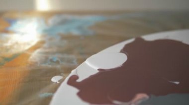 Sıvı akrilik atölyesi. Akışkan sanat. kadın elleri tuval üzerine akrilik boya döküyor. Yaratıcı çalışma