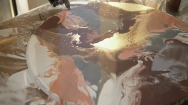 Sıvı akrilik atölyesi. Akışkan sanat. kadın elleri tuval üzerine akrilik boya döküyor. Yaratıcı çalışma