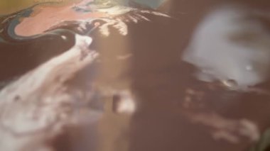 Sıvı akrilik atölyesi. Akışkan sanat. kadın elleri tuval üzerine akrilik boya döküyor. Yaratıcı çalışma