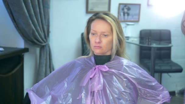 Haarfärbekonzept. Mädchen in einem Schönheitssalon. schaut sich selbst im Spiegel an, während sie Haare färbt — Stockvideo