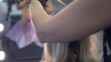 Close. saç boyama konsepti. kuaför renklendirici bir fırça ile bir kadının saç boyası