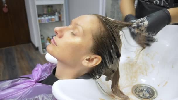 特写。染发概念。理发师用刷子染发女人的头发 — 图库视频影像