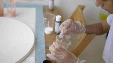 yakın çekim, tek kullanımlık bir fincan boya karıştırma. sanatçılar işyeri. tuval üzerine akrilik boyalar ile çalışmak için iş akışının hazırlanması. sanat sıvısı