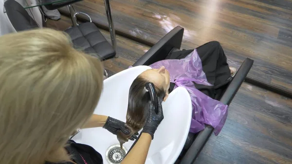 Processo de lavar o cabelo em um cabeleireiro. menina em um salão de beleza. lavar o cabelo, cuidados com o cabelo, saúde . — Fotografia de Stock