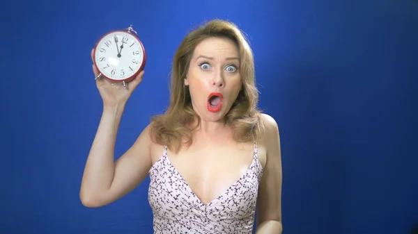 Surprised pin-up woman holding clock. Amazed pinup girl. Saving time concept. Summer sale. Discount. blue background Copy space. Expressive facial expressions. — Stock Photo, Image