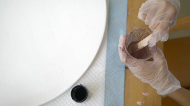 yakın çekim, tek kullanımlık bir fincan boya karıştırma. sanatçılar işyeri. tuval üzerine akrilik boyalar ile çalışmak için iş akışının hazırlanması. sanat sıvısı