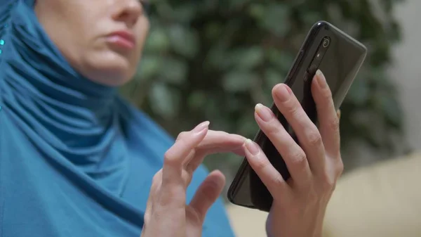 Крупным планом, мусульманка в хиджабе с помощью смартфона на открытом воздухе — стоковое фото