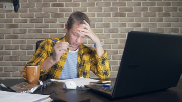 Um homem frustrado não pode se concentrar, tendo um bloco de escritores, uma falta de novas ideias, ou uma crise criativa. em um loft moderno — Vídeo de Stock