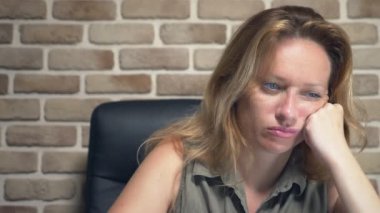 yaratıcı kriz kavramı, fikirleri engelleme. modern bir çatı katında bir dizüstü bilgisayar da oturan rahatsız kadın.