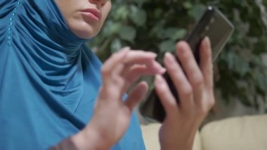 yakın çekim, açık havada akıllı telefon kullanarak hijab Müslüman kadın