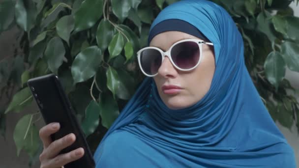 Close-up, mulher muçulmana no hijab usando smartphone ao ar livre — Vídeo de Stock