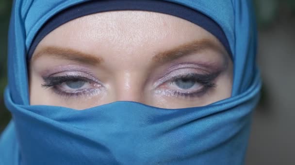 Close-up. mooie blauwe ogen van de Arabische jonge WoMA in traditionele islamitische doek niqab — Stockvideo