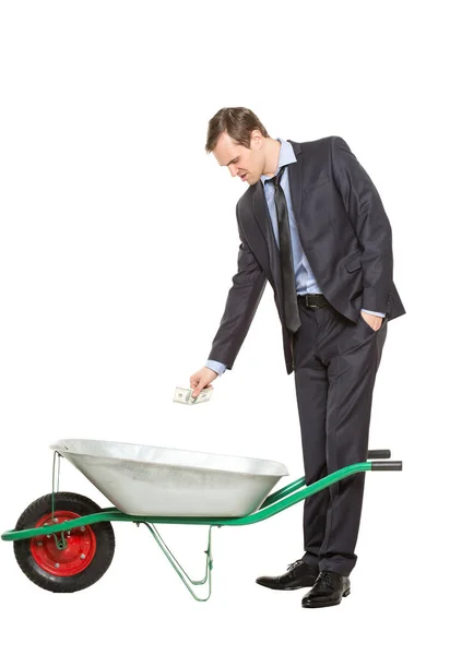Allegorie. kantoormedewerker, Manager, zakenman in een pak en stropdas met een kruiwagen, geïsoleerd op een witte achtergrond. — Stockfoto