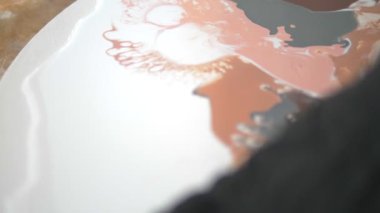 Sıvı akrilik atölyesi. Akışkan sanat. kadın elleri tuval üzerine akrilik boya döküyor. Yaratıcı çalışma