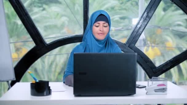 Hermosa mujer de negocios saudí en hijab trabajando en la oficina utilizando el ordenador portátil, espacio de copia — Vídeos de Stock