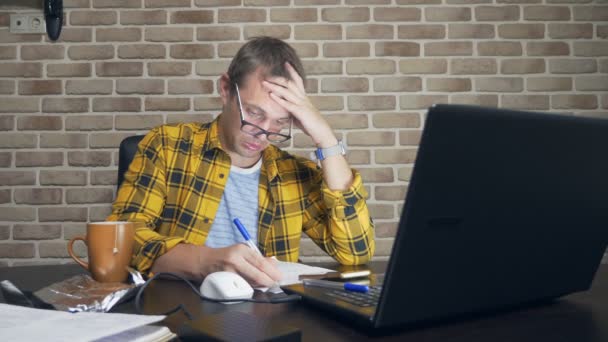 Un hombre frustrado no puede concentrarse, teniendo un bloque de escritores, una falta de nuevas ideas, o una crisis creativa. en un loft moderno — Vídeos de Stock