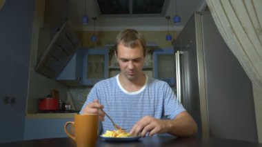 diyet konsepti, tatsız gıda. Sinirli ve rahatsız adam bir tabaktan yemek yemek ve hayal kırıklığına