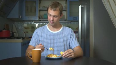 evde mutfakta oturan yemek yiyen rüya gibi adam