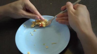 Yakından kapatın. sebze ile kızarmış yumurta. Birisi çatal ve elleriyle kızarmış yumurta yiyor. Nefis.