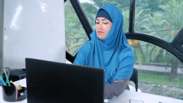 Hermosa mujer de negocios saudí en hijab trabajando en la oficina utilizando el ordenador portátil, espacio de copia — Vídeos de Stock