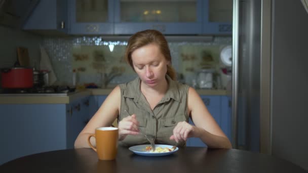 Étrend-koncepció, íztelen étel. Frusztrált és bosszantott nő eszik ételt egy tányér, és csalódott — Stock videók