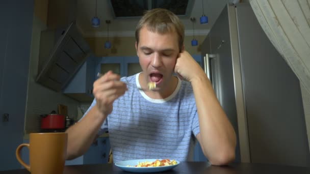 Δίαιτα, κακόγουστο φαγητό. Απογοητευμένος και ενοχλημένος άνθρωπος τρώγοντας φαγητό από ένα πιάτο και απογοητευμένος — Αρχείο Βίντεο
