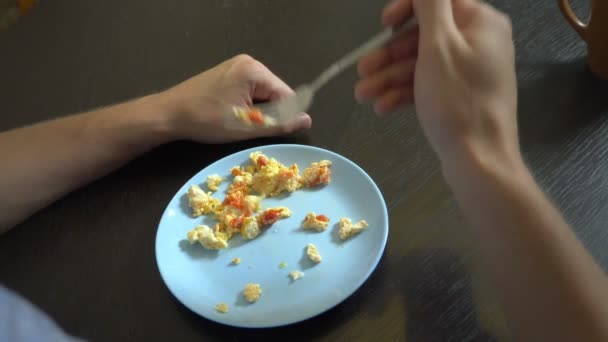 Närbild. stekt ägg med grönsaker. någon äter stekt ägg med en gaffel och händer. Yummy. — Stockvideo