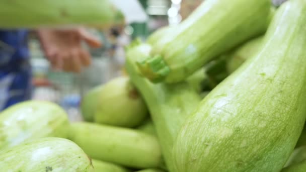 Primer plano. el comprador elige calabacín fresco en el supermercado — Vídeos de Stock