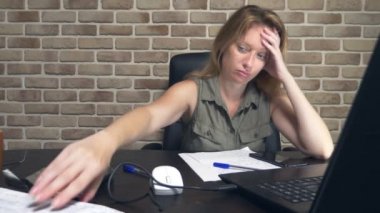 yaratıcı kriz kavramı, fikirleri engelleme. modern bir çatı katında bir dizüstü bilgisayar da oturan rahatsız kadın.