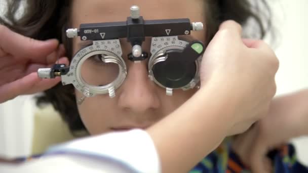 Γκρο πλαν. Έφηβος ασθενής με οπτομέτρη δοκιμαστικό πλαίσιο, συσκευή οπτικής επιθεώρησης. , οφθαλμίατρο εξέταση — Αρχείο Βίντεο