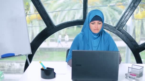 Bela mulher de negócios saudi no hijab trabalhando no escritório usando laptop, espaço de cópia — Vídeo de Stock