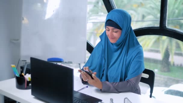 Hermosa mujer de negocios saudí en hijab trabajando en la oficina utilizando el ordenador portátil, espacio de copia — Vídeos de Stock