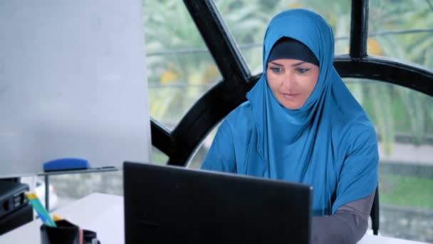 Hermosa mujer de negocios saudí en hijab trabajando en la oficina utilizando el ordenador portátil, espacio de copia — Vídeos de Stock