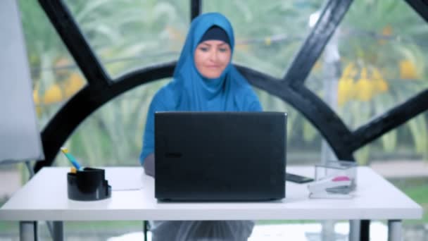 Hermosa mujer de negocios saudí en hijab trabajando en la oficina utilizando el ordenador portátil, espacio de copia — Vídeos de Stock