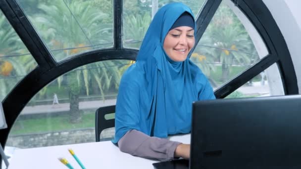 Hermosa mujer de negocios saudí en hijab trabajando en la oficina utilizando el ordenador portátil, espacio de copia — Vídeos de Stock