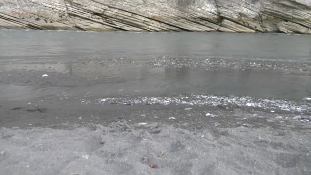 Das klare und wilde Wasser eines Gebirgsflusses, der in die Klippen einer Schlucht schlägt. Natur pur, eine Klippe mit viel Grün ganz oben, Sonne und Wasser. — Stockvideo