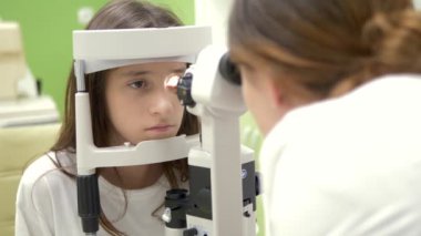 Oftalmoloji, optometri kavramı. Göz muayenesi için tıbbi oftalmik cihaz. genç kız bir doktor randevusunda görme kontrolleri, ekipman.