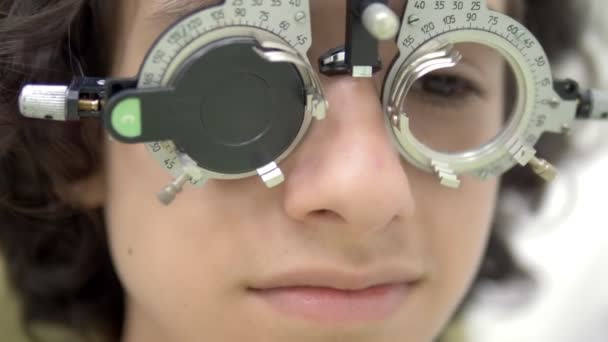 Close-up. tiener patiënt met optometrist trial frame, visuele inspectie apparaat. , oogarts onderzoek — Stockvideo