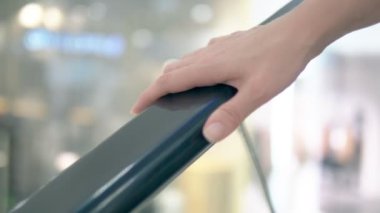 yürüyen merdiven korkuluk üzerinde kadın el tutan ve alışveriş merkezinin zemin yukarı gidiyor yürüyen merdiven sürme.