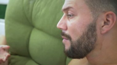 Mayo giyen bir adam ve bir kadın nargile içer, sahildeki çardakta kokteyl içer.