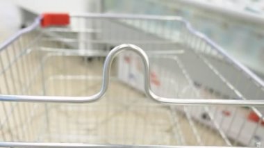 odak alışveriş arabası yakın çekim. bulanık arka plan. alıcılar süpermarkette ürünleri seçin.
