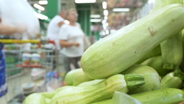 Primer plano. el comprador elige calabacín fresco en el supermercado — Vídeo de stock