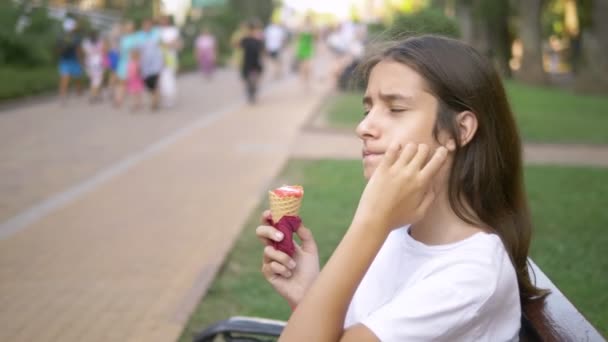 Teen κορίτσι τρώει παγωτό σε εξωτερικούς χώρους. Η έννοια της παιδικής ηλικίας, του τρόπου ζωής, της τροφής, του καλοκαιριού. — Αρχείο Βίντεο