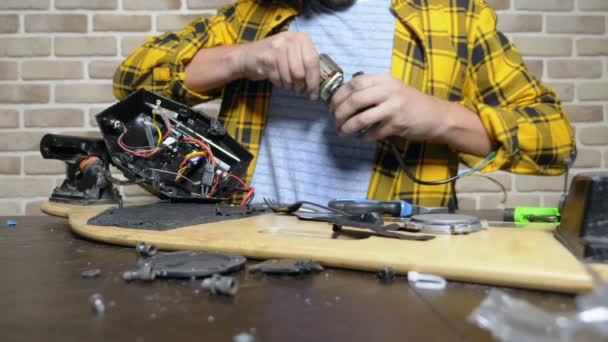 Mecánico reparando un motor eléctrico de un patín eléctrico. rodamiento de cerca — Vídeos de Stock