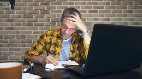 Um homem frustrado não pode se concentrar, tendo um bloco de escritores, uma falta de novas ideias, ou uma crise criativa. em um loft moderno — Fotografia de Stock