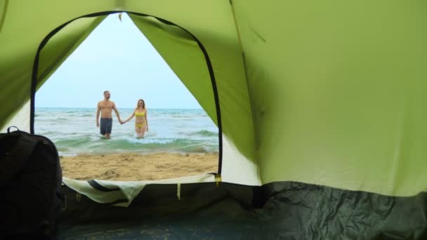 Camping konceptet vid havet. utsikt från tältet, ett par man och kvinna krama, — Stockvideo